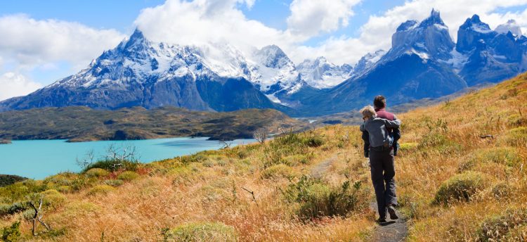family of two father and son enjoying hiking and active travel in torres del paine national park in patagonia chile view of cuernos del paine and pehoe lake