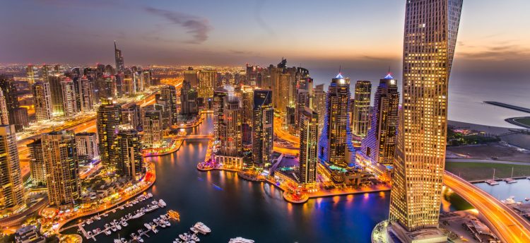 Dubai Marina at Blue hour, Glittering lights and tallest skyscrapers during a clear evening with Blue sky.