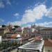 Beautiful cityscape of Lisbon showcasing historic architecture and iconic rooftops under a vibrant blue sky.
