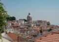 Beautiful view of Lisbon's traditional red rooftops with a prominent dome in the background.