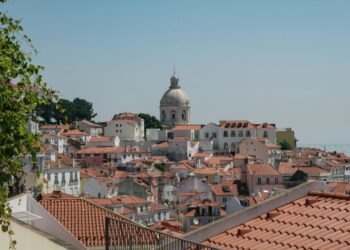 Beautiful view of Lisbon's traditional red rooftops with a prominent dome in the background.