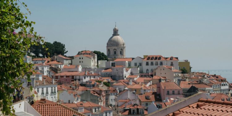 Beautiful view of Lisbon's traditional red rooftops with a prominent dome in the background.