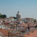 Beautiful view of Lisbon's traditional red rooftops with a prominent dome in the background.