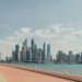 Beautiful view of Dubai Marina's skyscrapers along a sunny waterfront promenade.