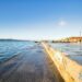 Bright waterfront scene with clear sky and boats in Lisbon, Portugal.