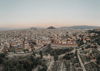 Greece Golden Visa: thresholds double and demand persists — A stunning aerial view of Athens cityscape at sunrise, showcasing historical landmarks.