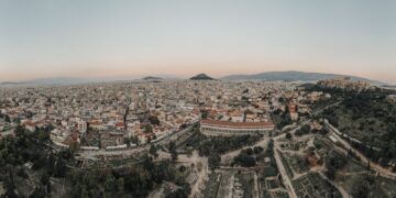Greece Golden Visa: thresholds double and demand persists — A stunning aerial view of Athens cityscape at sunrise, showcasing historical landmarks.