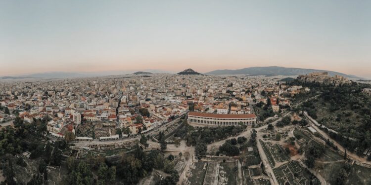 Greece Golden Visa: thresholds double and demand persists — A stunning aerial view of Athens cityscape at sunrise, showcasing historical landmarks.
