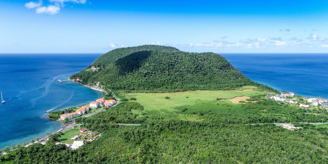 Cheapest Citizenship by Investment 2026: Dominica and Caribbean Comparison — Stunning aerial view of a tropical island surrounded by the azure Caribbean Sea. Perfect for travel imagery.