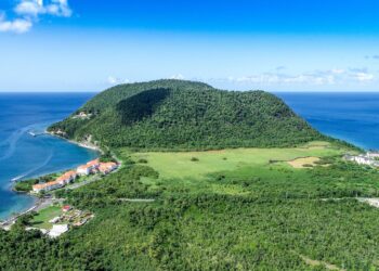 Cheapest Citizenship by Investment 2026: Dominica and Caribbean Comparison — Stunning aerial view of a tropical island surrounded by the azure Caribbean Sea. Perfect for travel imagery.