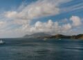 St. Kitts Citizenship by Investment: Complete 2026 Guide — A picturesque Caribbean seascape featuring luxury yachts, ocean, hills, and a vibrant sky.