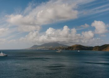 St. Kitts Citizenship by Investment: Complete 2026 Guide — A picturesque Caribbean seascape featuring luxury yachts, ocean, hills, and a vibrant sky.