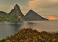 Citizenship by Investment St Lucia: 2026 Complete Programme Guide — A breathtaking sunset view of the Pitons in St. Lucia with lush greenery and calm sea.