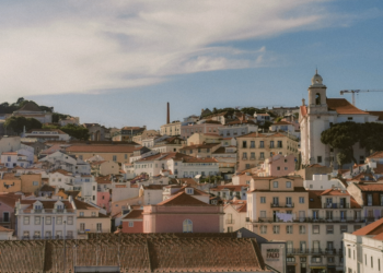 Portugal Citizenship by Investment: 2026 Rules, Timeline & Investor Backlash — Aerial view of Lisbon's charming historic architecture under a bright sky.