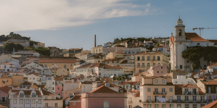 Portugal Citizenship by Investment: 2026 Rules, Timeline & Investor Backlash — Aerial view of Lisbon's charming historic architecture under a bright sky.