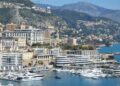 How to Become a Monaco Tax Resident: Complete 2025 Guide — A stunning view of Monaco's harbor, cityscape, and yachts docked under a clear sky.