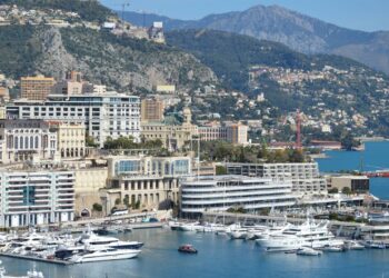 How to Become a Monaco Tax Resident: Complete 2025 Guide — A stunning view of Monaco's harbor, cityscape, and yachts docked under a clear sky.