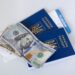 Apply for Second Passport: Same-Country Duplicates vs Citizenship Acquisition — Close-up view of Ukrainian passports with US dollar bills, symbolizing travel readiness.