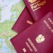 Applying for a Second Passport: Rules, Timelines and Documentation — Close-up of European passports from Portugal and Austria on a world map.