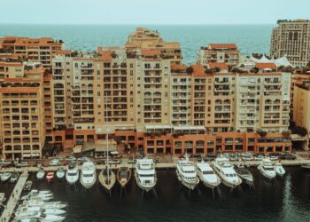 Tax-Free Countries in Europe: Monaco, Gibraltar and Territorial Rules — A stunning aerial photo showcasing luxury yachts moored at a waterfront with apartment buildings in Monaco.