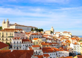 Portugal Citizenship by Investment: What Changed in 2026 and What Works Now — A scenic view over Lisbon's historic Alfama district showcasing traditional architecture under a clear sky.