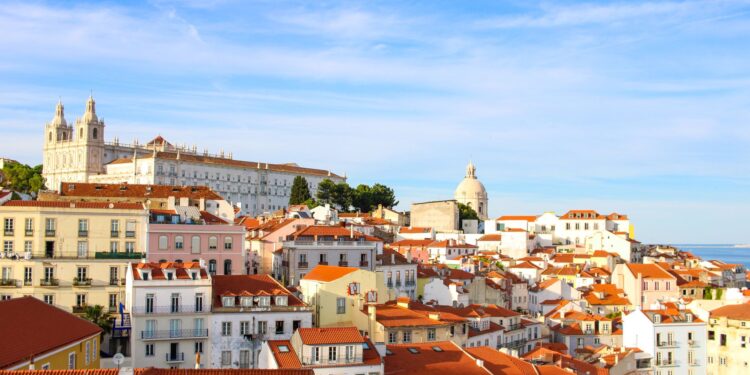 Portugal Citizenship by Investment: What Changed in 2026 and What Works Now — A scenic view over Lisbon's historic Alfama district showcasing traditional architecture under a clear sky.