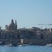 Citizenship by Investment Malta: What Ended and What Remains in 2026 — Beautiful view of Valletta with boats in foreground, highlighting iconic architecture under a clear blue sky.