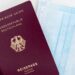 Europe Citizenship by Investment: What Remains After the 2025 CJEU Ruling — Top view of a German passport next to a surgical mask, symbolizing travel during pandemic.