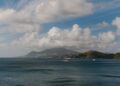 St. Kitts Citizenship by Investment: Complete 2026 Guide — A picturesque Caribbean seascape featuring luxury yachts, ocean, hills, and a vibrant sky.