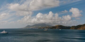 St. Kitts Citizenship by Investment: Complete 2026 Guide — A picturesque Caribbean seascape featuring luxury yachts, ocean, hills, and a vibrant sky.