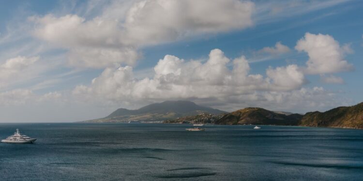 St. Kitts Citizenship by Investment: Complete 2026 Guide — A picturesque Caribbean seascape featuring luxury yachts, ocean, hills, and a vibrant sky.