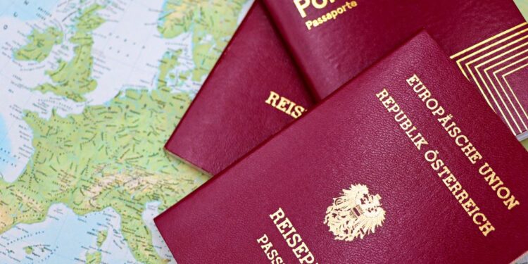 Applying for a Second Passport: Rules, Timelines and Documentation — Close-up of European passports from Portugal and Austria on a world map.