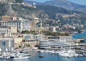 How to Become a Monaco Tax Resident: Complete 2025 Guide — A stunning view of Monaco's harbor, cityscape, and yachts docked under a clear sky.