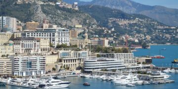 How to Become a Monaco Tax Resident: Complete 2025 Guide — A stunning view of Monaco's harbor, cityscape, and yachts docked under a clear sky.