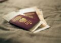 Second Passport: Investment Routes and Costs in 2026 — A close-up of a Polish passport and travel documents placed on a fabric surface, symbolizing travel and identity.