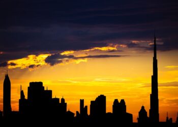 Dubai Golden Visa: Official Investment Minimums and Application Routes — Captivating silhouette of Dubai's skyline with vibrant sunset colors and Burj Khalifa dominating the scene.