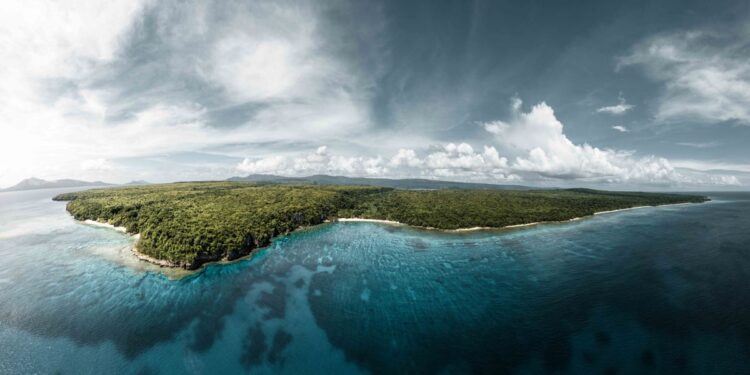 Vanuatu Citizenship by Investment: 2026 Programme Guide — A breathtaking aerial view of the lush green coastline of Vanuatu, surrounded by crystal clear waters.