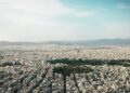 Greece Golden Visa 2026: €250k Property Rules, Tax Residency & Renewal — Aerial view of Athens cityscape showcasing urban density with mountains in the background.