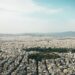 Greece Golden Visa 2026: €250k Property Rules, Tax Residency & Renewal — Aerial view of Athens cityscape showcasing urban density with mountains in the background.