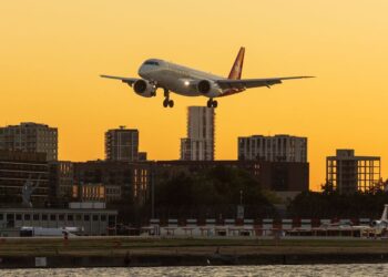 Aircraft over a city skyline, illustrating wealth migration