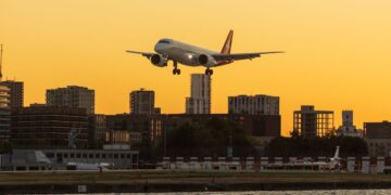 Aircraft over a city skyline, illustrating wealth migration