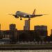 Aircraft over a city skyline, illustrating wealth migration