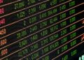Mumbai stock exchange trading floor with electronic displays showing market data