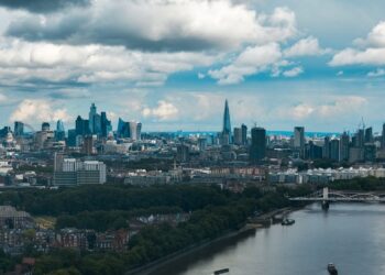 Aerial view of the City of London skyline and the River Thames, illustrating millionaires leaving the UK