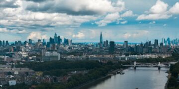 Aerial view of the City of London skyline and the River Thames, illustrating millionaires leaving the UK