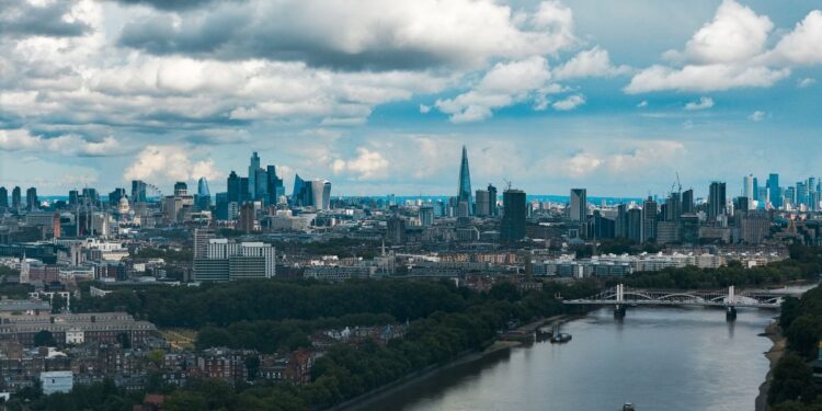 Aerial view of the City of London skyline and the River Thames, illustrating millionaires leaving the UK